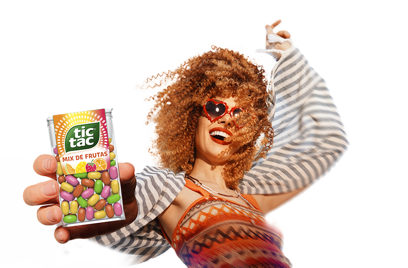 Imagem com fundo em degradê de por do sol, com multidão em frente ao palco do festival com logotipo de Tic Tac® e Lollapalooza acima, mulher sorrindo com look despojado e segurando Tic Tac® Mix de Frutas.